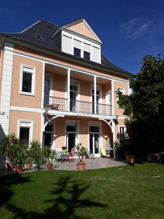 Cette grande maison rose dispose d'un balcon et d'une cour. dans l'établissement Chambres Rue De Lorry, à Bagnères-de-Bigorre