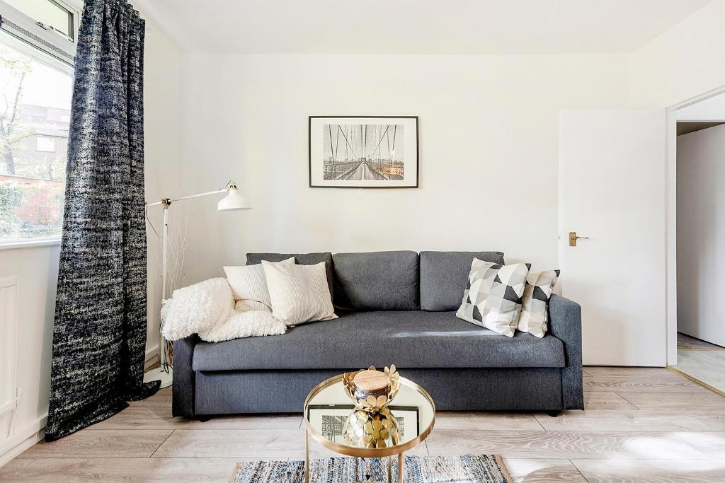 a living room with a couch and a glass table at CS Apartments Bayswater in London
