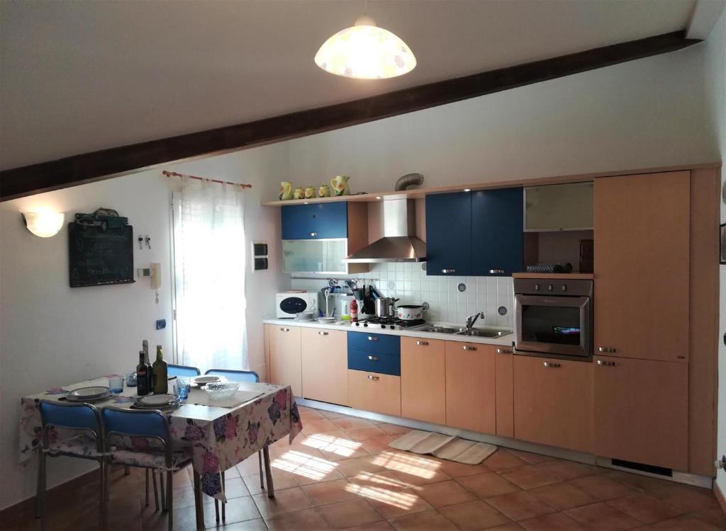 a kitchen with blue cabinets and a table in it at House Mare e Monti by Holiday World in Albenga