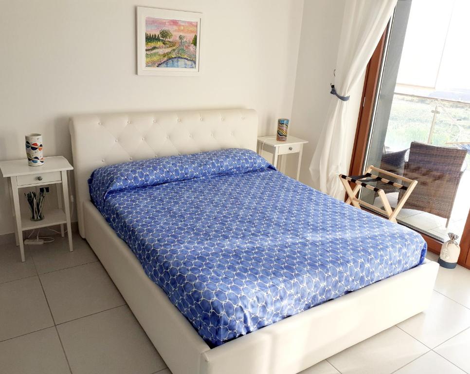 a bedroom with a bed with a blue comforter at B&B Suite Vela Bianca in Salerno