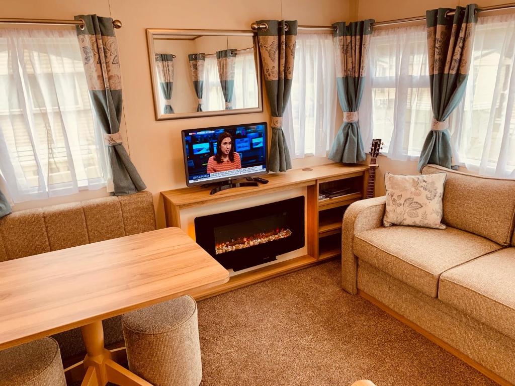 a living room with a tv and a couch at Shorefield country Park, in Milford on Sea