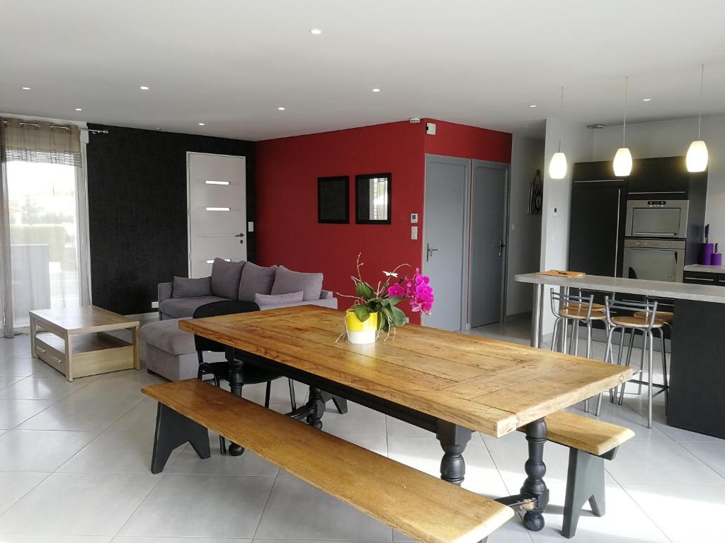 eine Küche und ein Wohnzimmer mit einem Holztisch in der Unterkunft Maison lumineuse in Les Herbiers