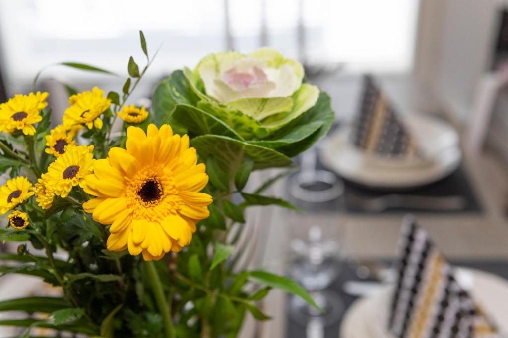 a vase filled with yellow flowers on a table at Tuomas´ luxurious suites, Kaakkuri in Rovaniemi