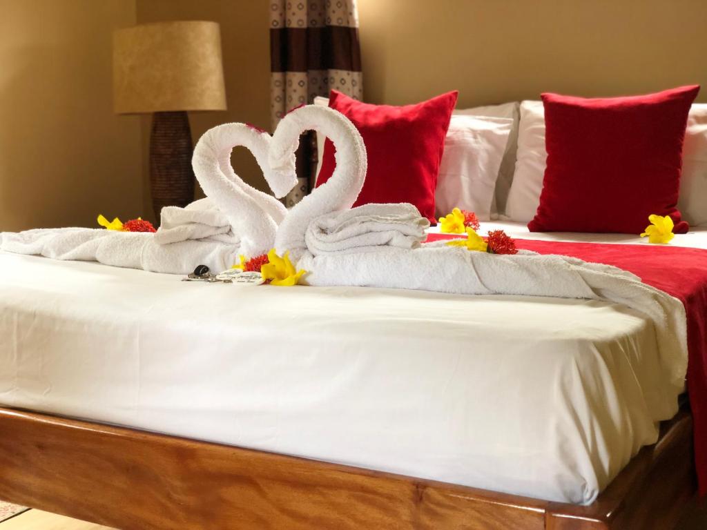 two towels and two swans on a bed at Mountain Lodge in Anse Possession