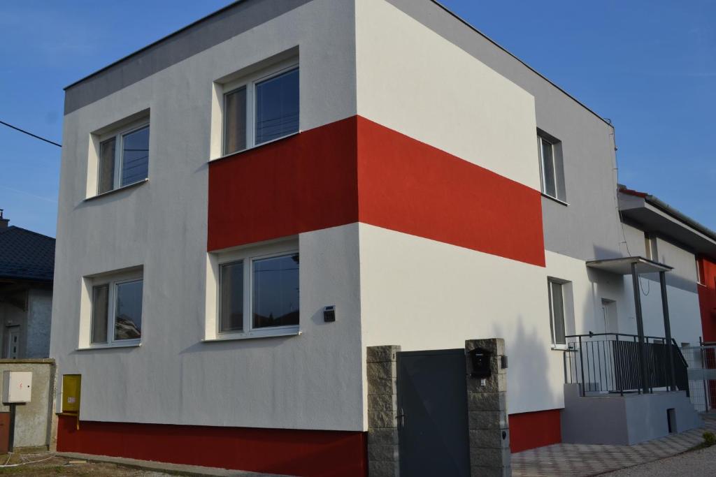 ein Gebäude mit einer rot-weißen Fassade in der Unterkunft Ubytovanie Alex in Sládečkovce