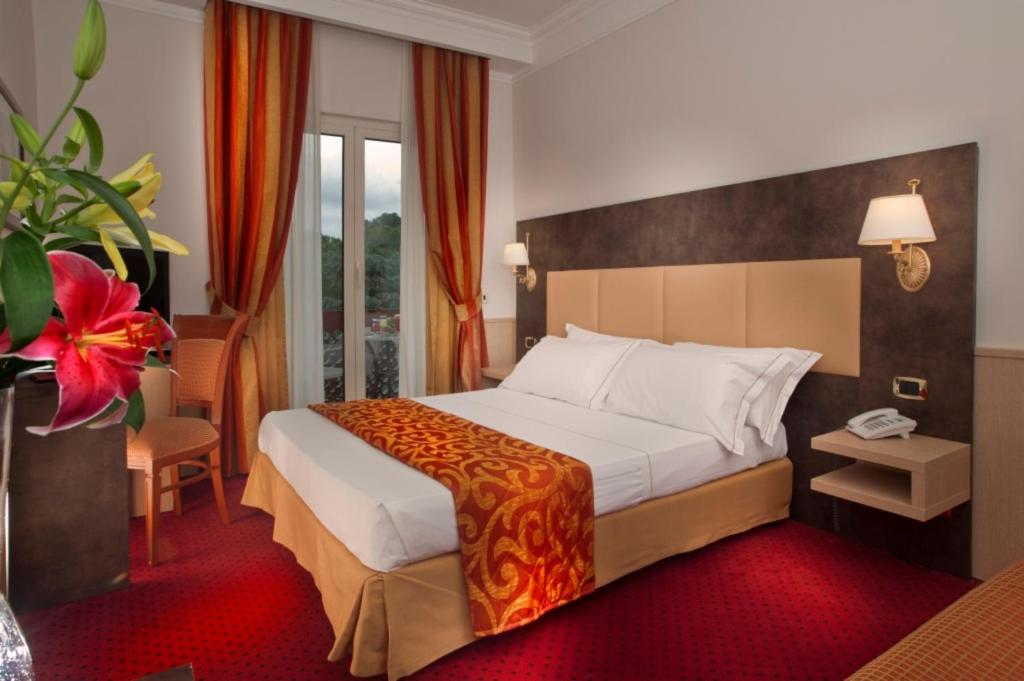 ローマにあるパインウッド ホテル ローマの赤いカーペット敷きの客室で、ベッド1台が備わります。