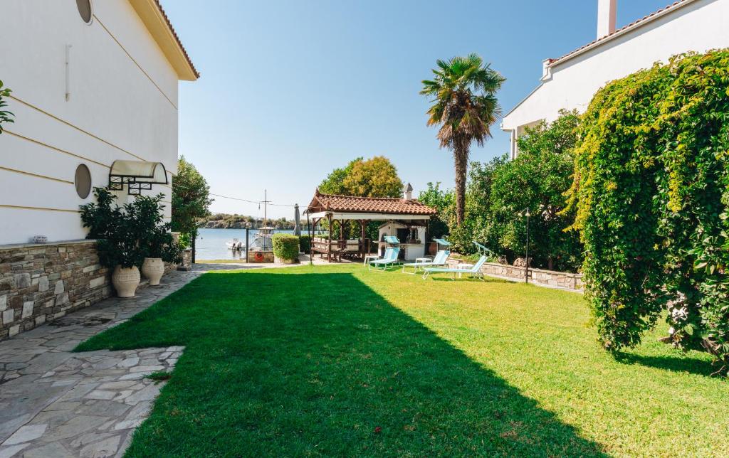a yard with green grass and a house at Kesi beach house in Volos