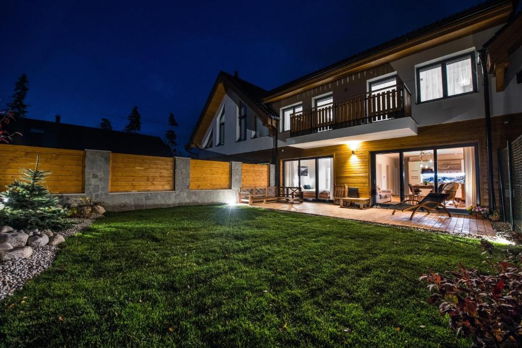a backyard of a house at night at Lomnica Garden Apartment in Tatranská Lomnica