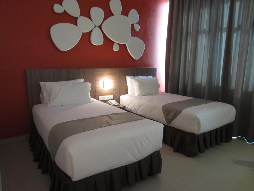 two beds sitting next to each other in a room at D Hotel in Seri Iskandar