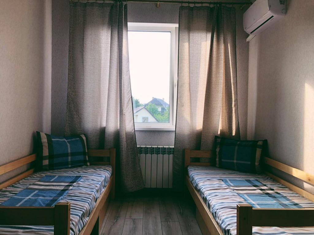 2 łóżka w małym pokoju z oknem w obiekcie Annet w Charkowie