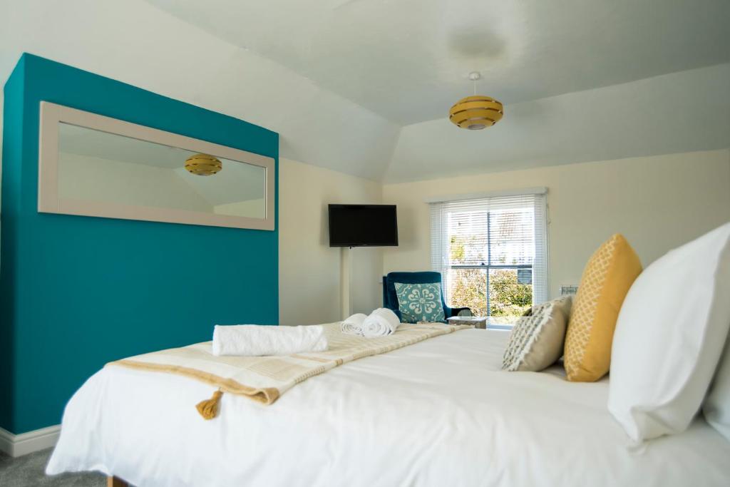 um quarto com uma cama grande e uma parede azul em Victoria Inn em Penzance