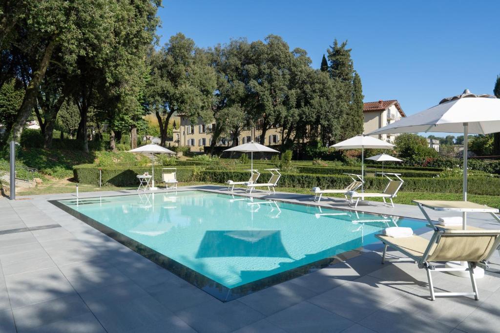 a swimming pool with chairs and umbrellas at Villa Gerini in Ronta