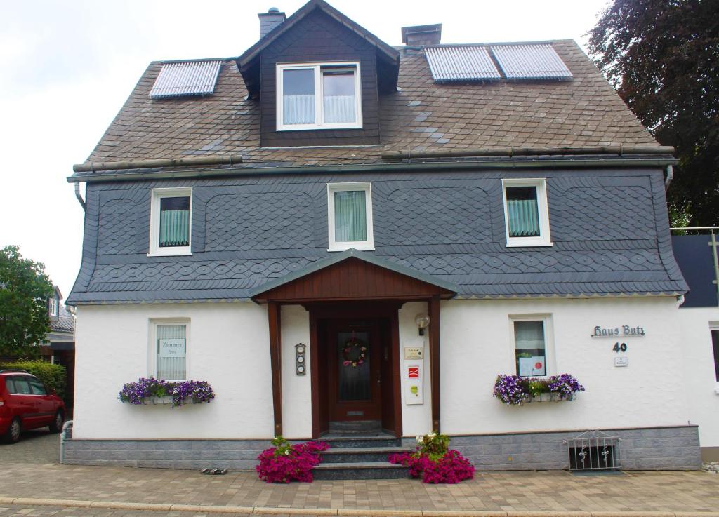 uma casa branca com painéis solares no telhado em Pension Haus Butz em Winterberg