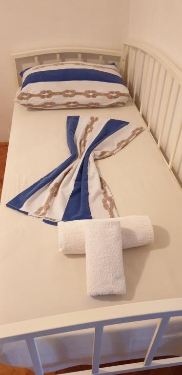 Una cama con sábanas azules y blancas y toallas. en Apartment Sliskovic, en Vis