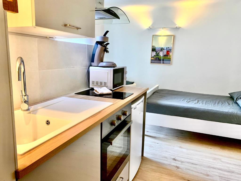 a small kitchen with a sink and a bed at PERLE Studio in Manosque