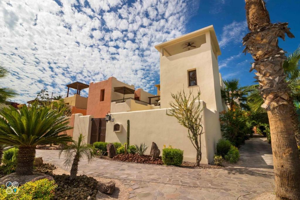 a building with a palm tree in front of it at Casa Del Vino 2BR by Casago in Loreto