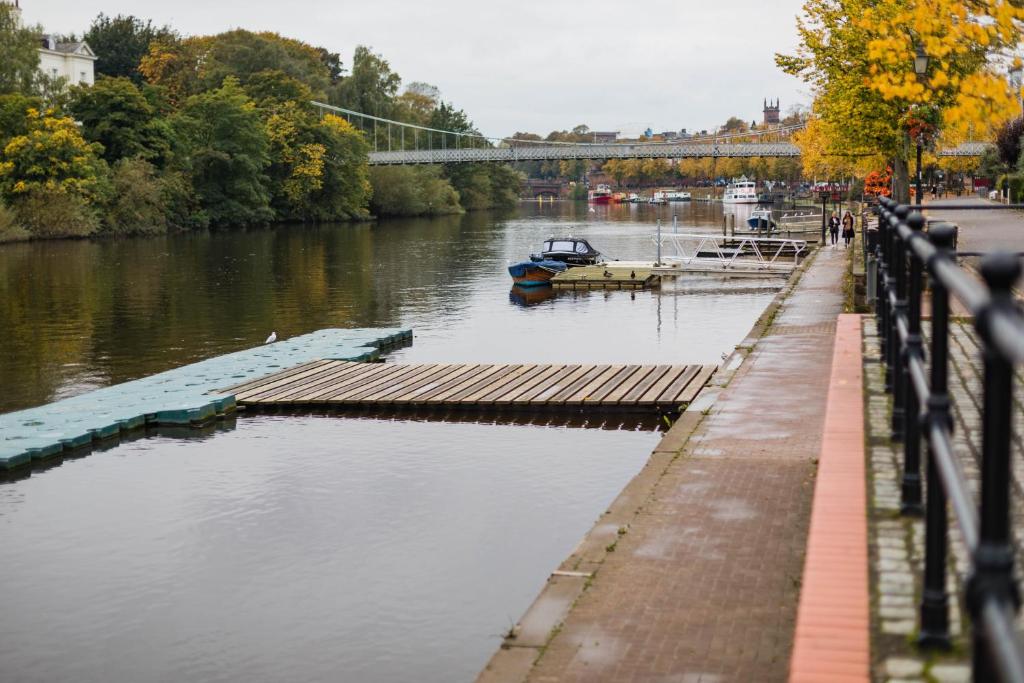 une rivière avec un quai et un bateau dans l'eau dans l'établissement Central BnB with secure parking, à Chester