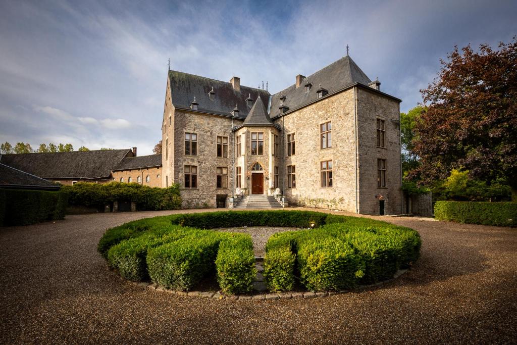 un viejo castillo con un seto delante de él en Château Wittem en Wittem