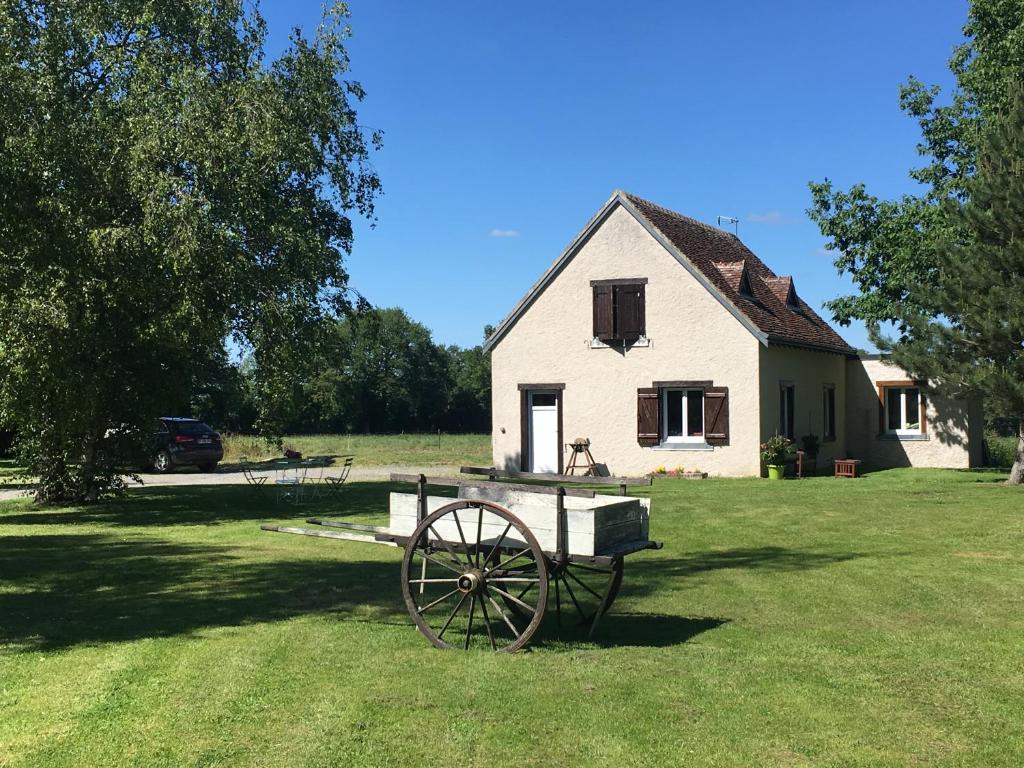 a white house with a wagon in front of it at Domaine des cossères in Neuvy-Saint-Sépulchre