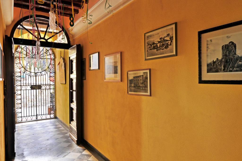 einen Flur mit orangefarbener Wand mit Bildern darauf in der Unterkunft Sul Prado in Pietrasanta