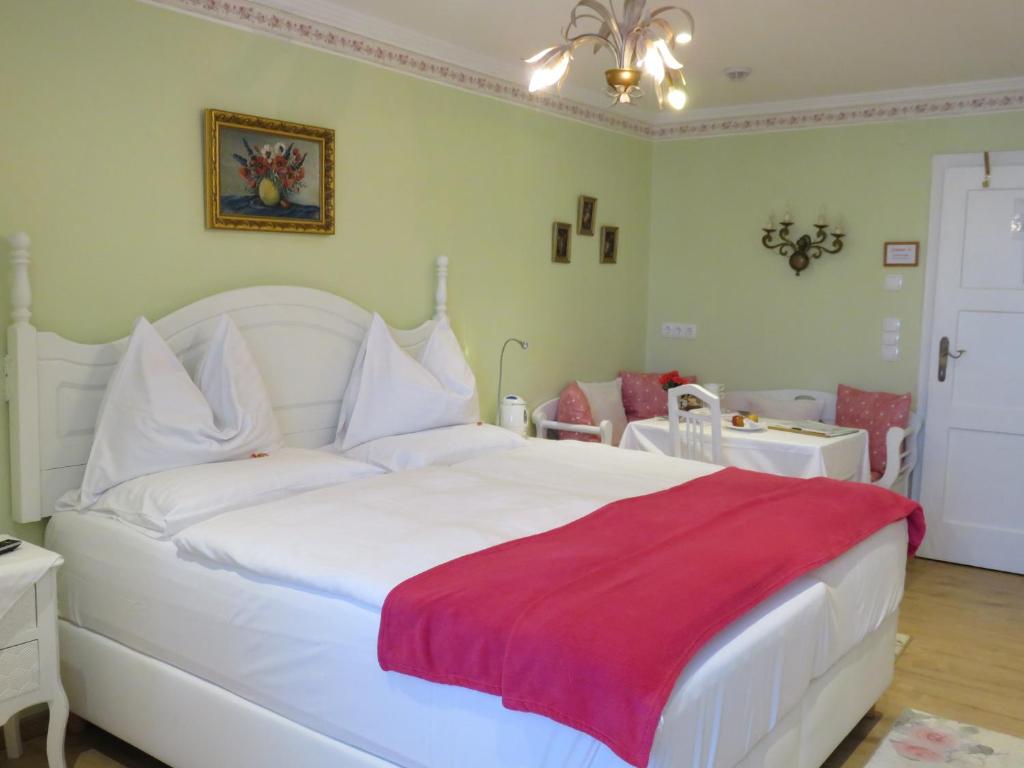 ein Schlafzimmer mit einem weißen Bett mit einer roten Decke in der Unterkunft Hotel Schneider-Gössl in Wien