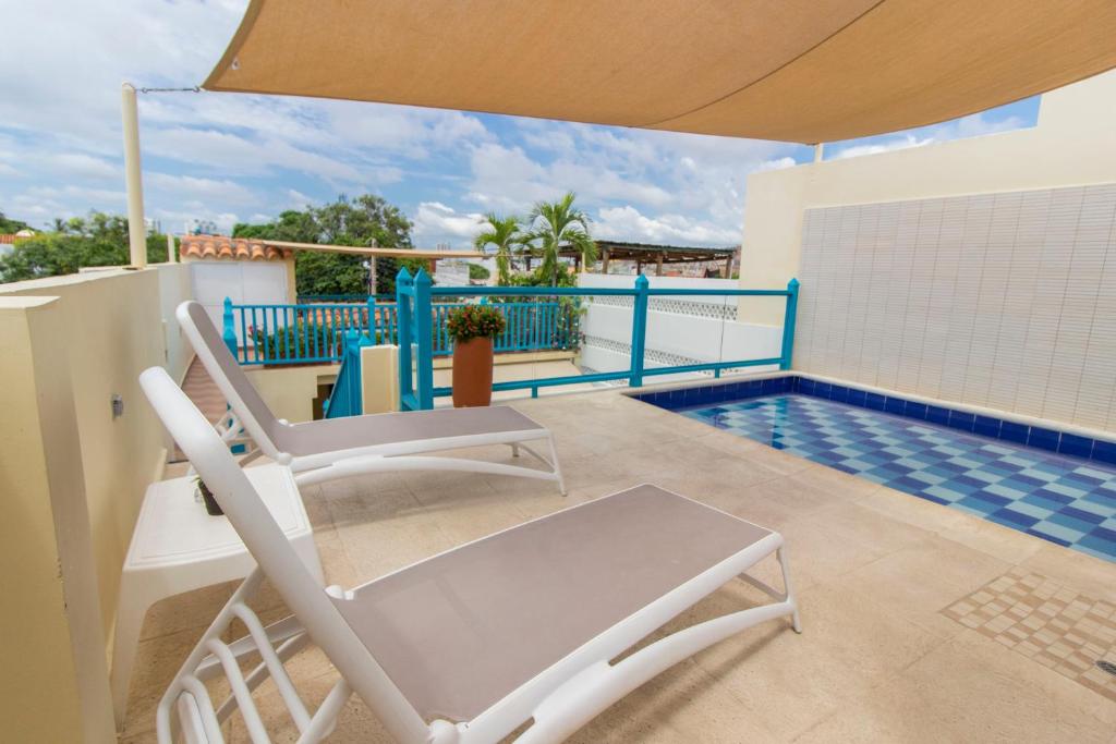 een balkon met een stoel en een zwembad bij Posada La Fe by BespokeColombia in Cartagena