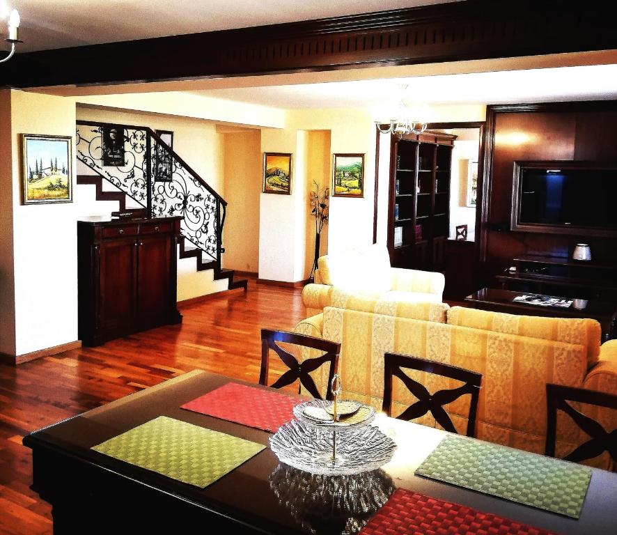 Penthouse Renașterii Amazonia في تيميشوارا: غرفة معيشة مع أريكة وطاولة