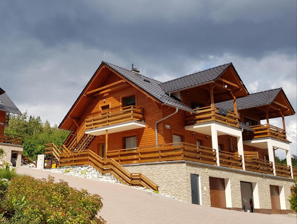 a large wooden house with wooden stairs on it at Apartament Dorota z garażem in Szklarska Poręba