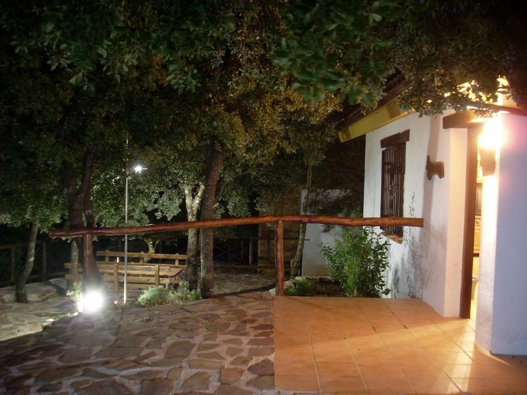 Casas Rurales Cortijos el Encinar في توريس: شرفة منزل في الليل مع سياج