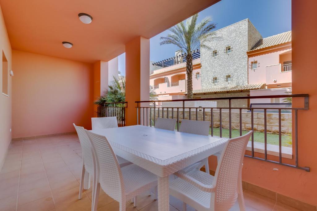 a dining room with a white table and chairs on a balcony at Victoria Boulevard - Vasco da Gama - Vilamoura in Vilamoura