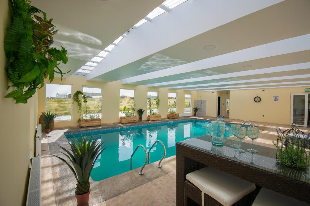 a large swimming pool in a building with a pool at Angelica's Rental House in Puerto Natales