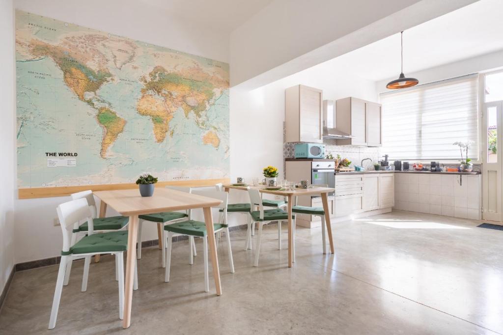 a kitchen with two tables and a world map on the wall at 40° Parallelo Guest House in Riola Sardo