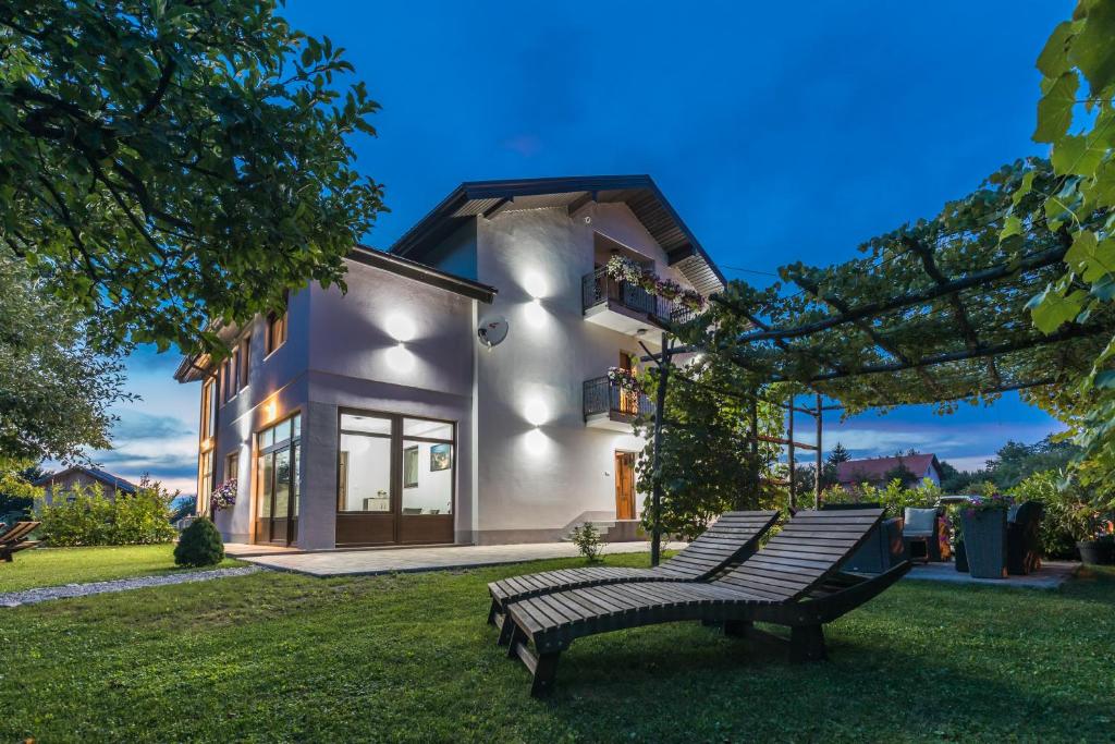 a couple of benches in front of a house at Apartments Lucić in Slunj