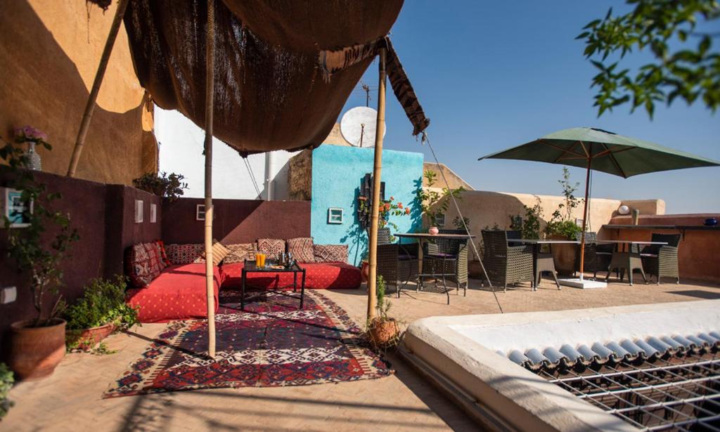 非斯的住宿－Dar anne，一个带遮阳伞和桌椅的庭院。