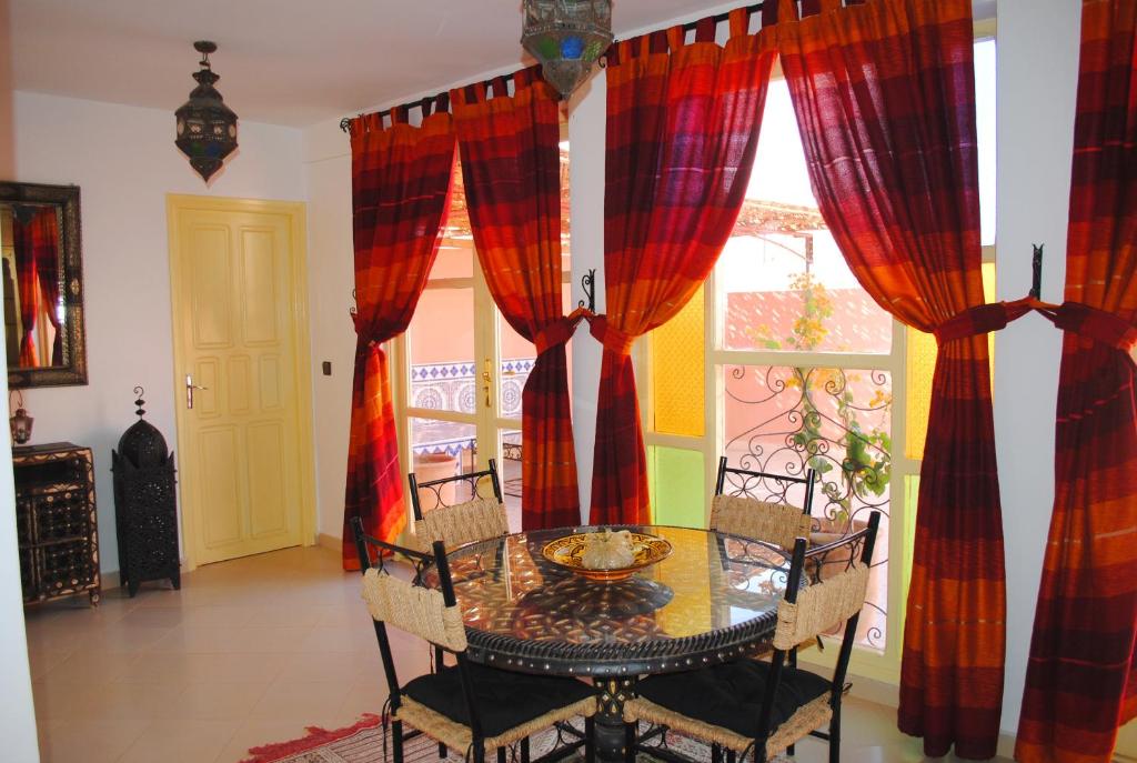 een eetkamer met een tafel en stoelen en een raam bij Appartement Anatim in Ouarzazate