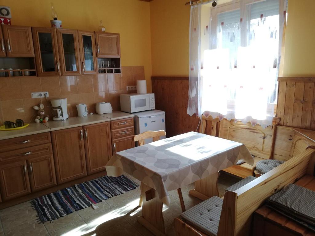 een keuken met een tafel en een tafel en een magnetron bij Apartment in Balatonszemes 38456 in Balatonszemes
