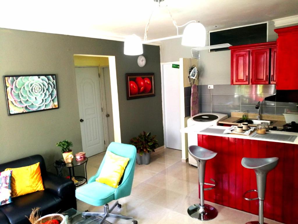 cocina con armarios rojos y sillas azules en una habitación en Moderno Y Elegante en Santo Domingo