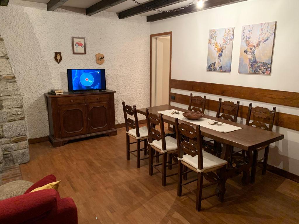 a dining room with a table and a tv at Snow peak in Ponte di Legno