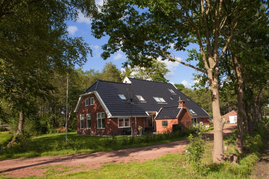 een groot huis met een gambrel dak bij Studio de Kaap in Roden
