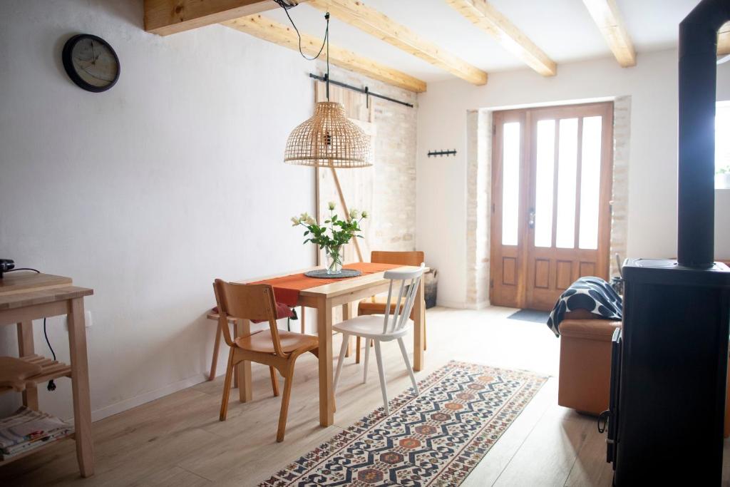 uma sala de jantar com uma mesa de madeira e cadeiras em Little house - Hiška em Izola