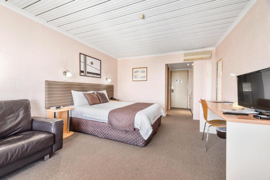 a hotel room with a bed and a desk and a tv at Balmoral On York in Launceston