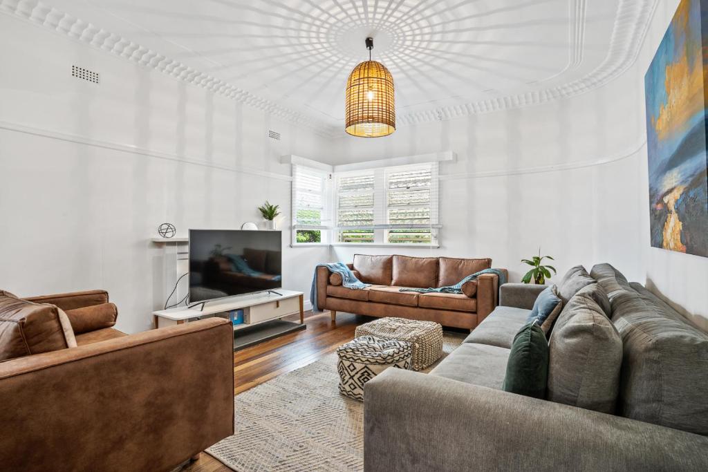 uma sala de estar com dois sofás e uma televisão em Hideaway on Keats - Keats Street, Byron Bay em Byron Bay