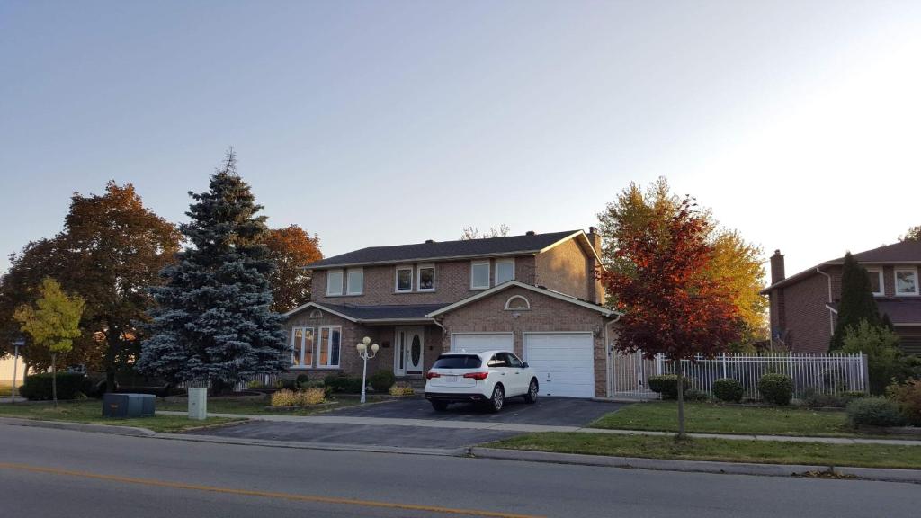 a white truck parked in front of a house at Comfort Rooms near Toronto Airport in Mississauga