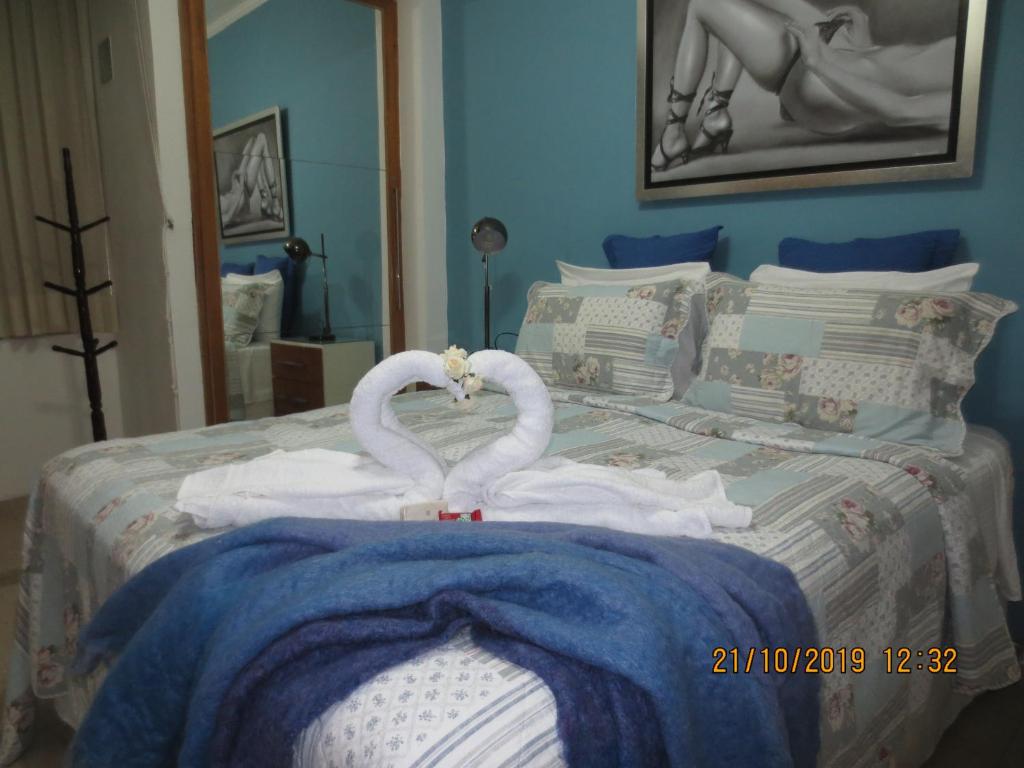 Dos cisnes hechos de toallas en una cama en Constante Ramos com Wifi, en Río de Janeiro