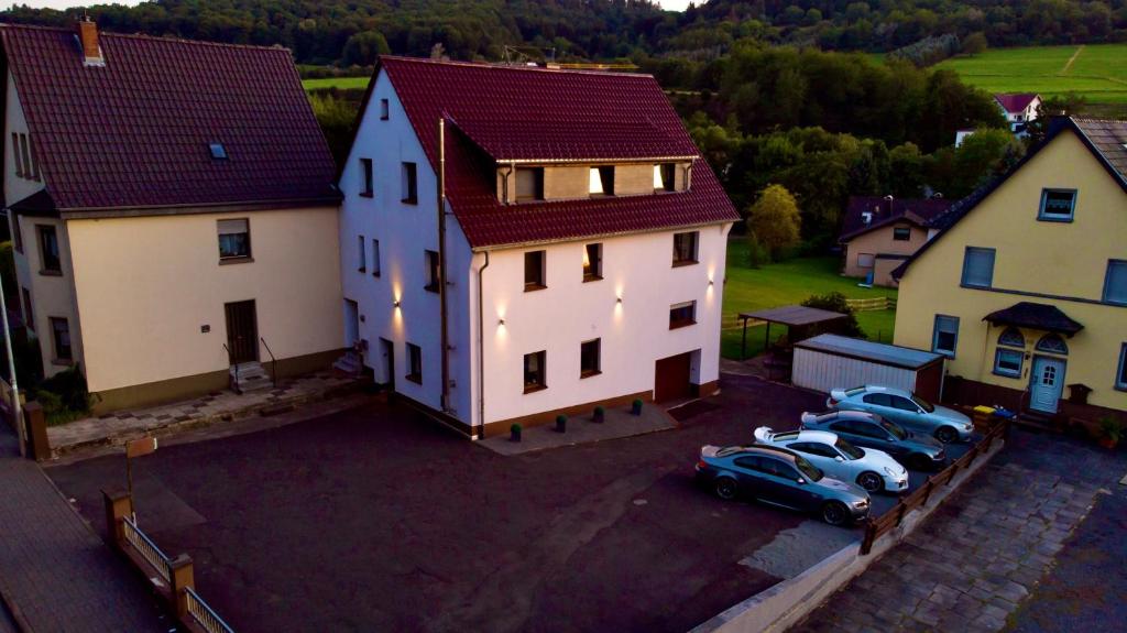una vista aérea de una casa con coches aparcados en un aparcamiento en North Loop Rooms en Adenau