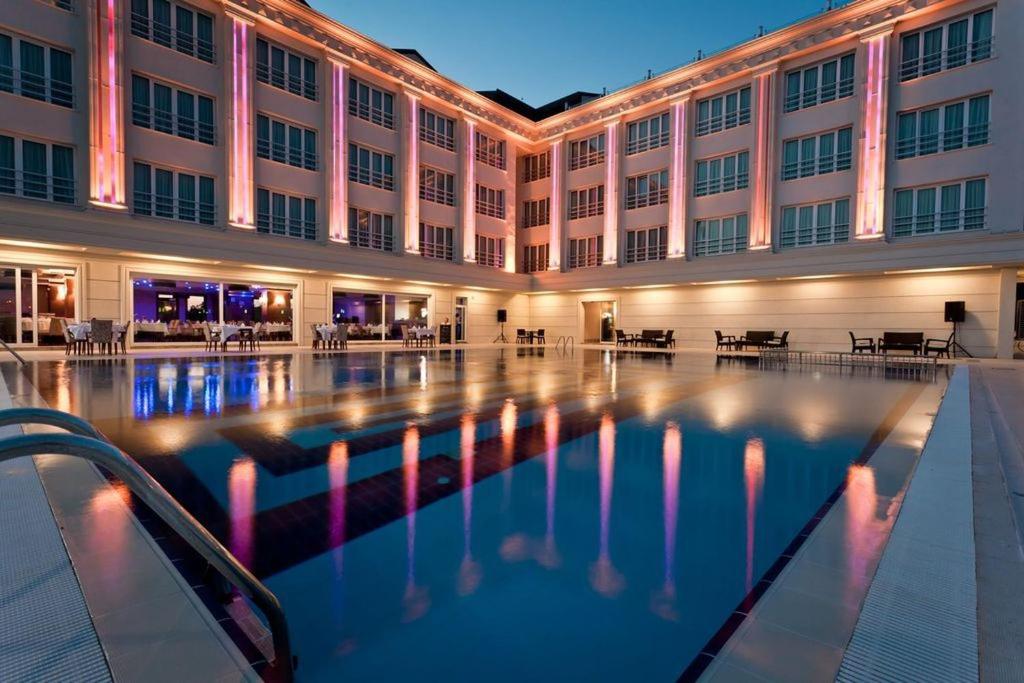 ブユクツェクメツェにあるMercia Hotels & Resortsの大きな建物の正面にプールがあります。
