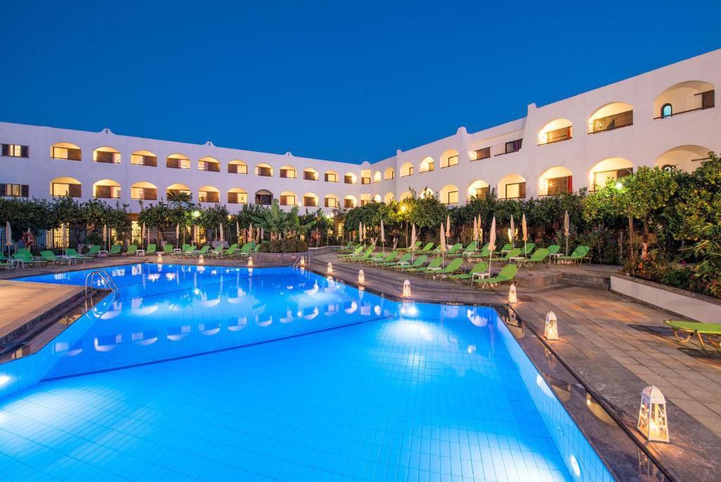 a swimming pool in front of a building at Hotel Malia Holidays in Malia