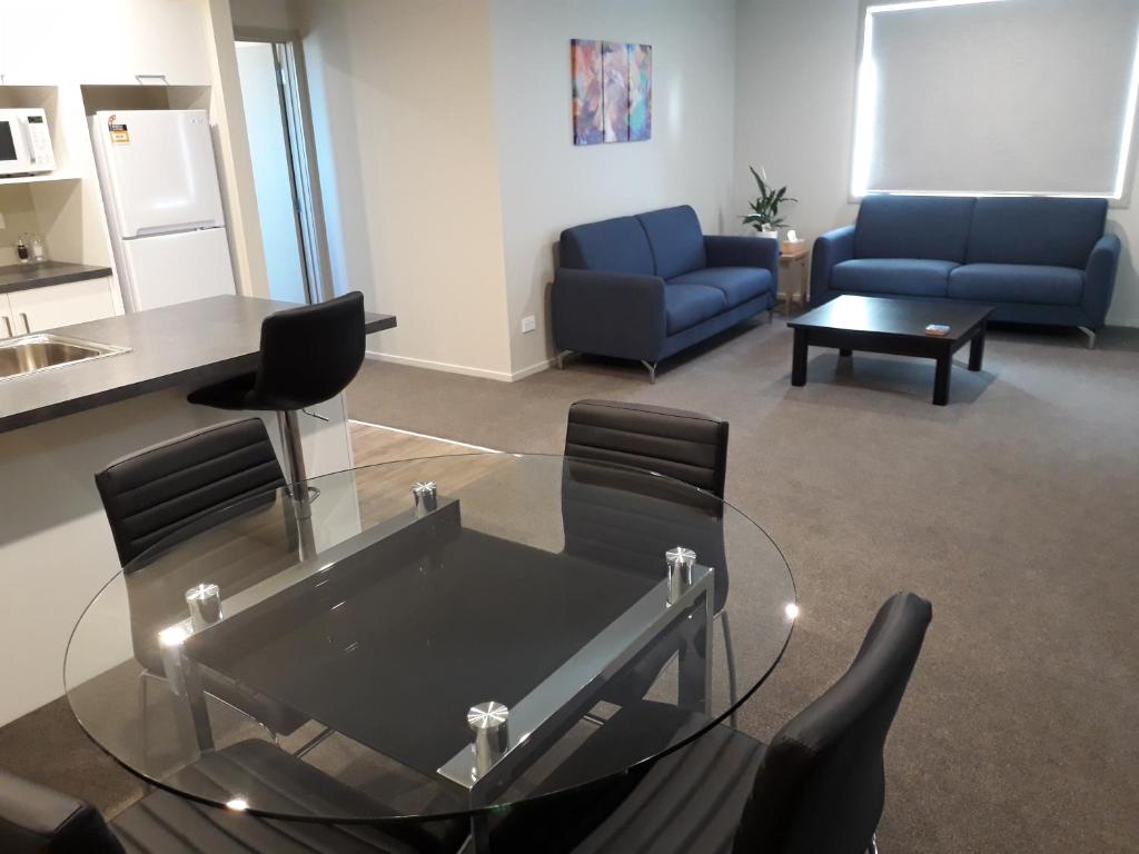 a living room with a glass table and chairs at South City Accommodation Unit 2 in Invercargill