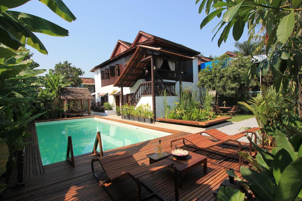 a house with a swimming pool and a wooden deck at Wat Bo House in Siem Reap