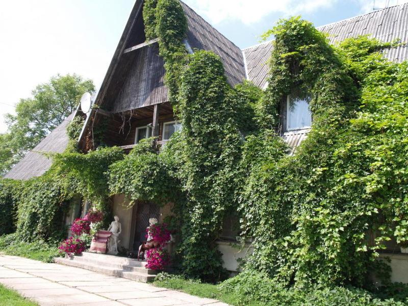 a house with ivy growing on the side of it at Upmaļi in Tērvete